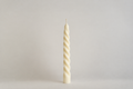 Spiral Candles, candela alta a spirale tortile color avorio, vista frontale su fondo grigio chiaro