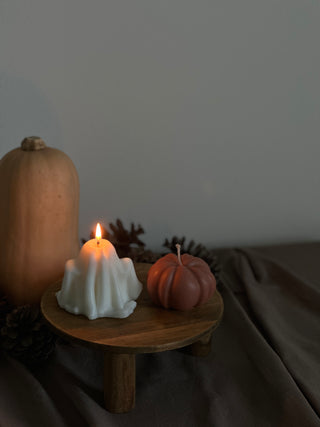 Candela di Halloween a forma di fantasma grande accanto a una zucca color terracotta.