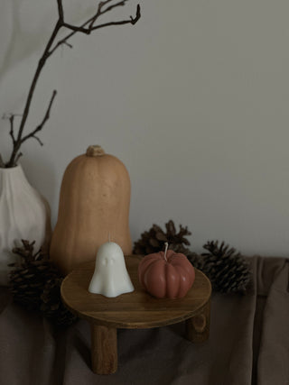 Candela di Halloween a forma di fantasma piccolo accanto a una zucca color terracotta.