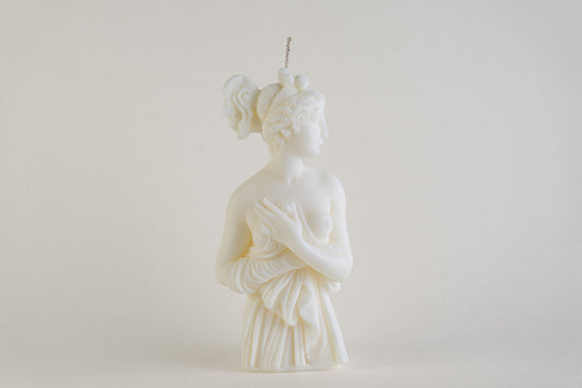 Candela scultorea Lady Aphrodite color avorio, raffigurata a figura intera su sfondo chiaro.