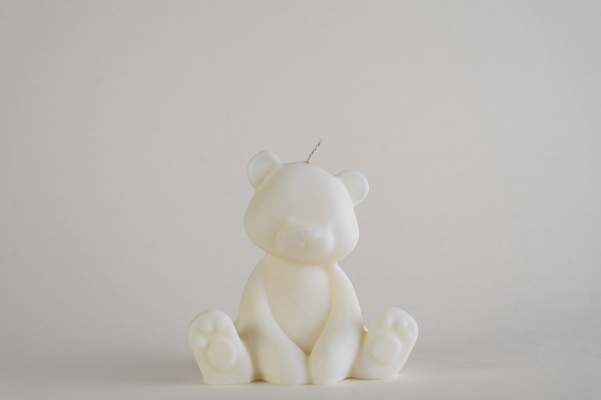 Teddy Bear Candle, candela a forma di orsetto seduto, color avorio, vista frontale su fondo grigio chiaro