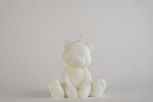 Teddy Bear Candle, candela a forma di orsetto seduto, color avorio, vista frontale su fondo grigio chiaro