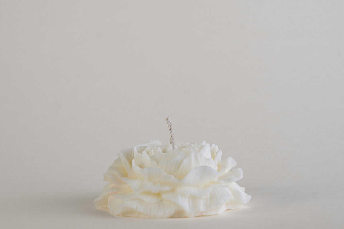 	Peony Candle, candela a forma di peonia in fiore, color avorio, vista frontale su fondo grigio chiaro
