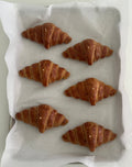 Candele a forma di croissant disposte su una teglia.