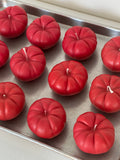Candele a forma di pomodoro disposte su un piatto da portata.
