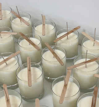 Candele profumate Hot&Vintage in preparazione, in vasetti di vetro con lo stoppino fissato da stecchetti di legno