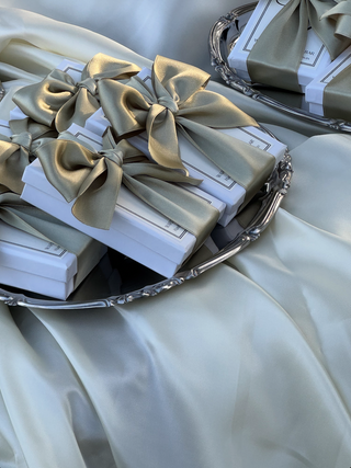 Confezioni regalo Hot&Vintage per evento, scatole bianche con fiocco di raso verde salvia su un vassoio d'argento