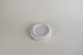 Small Round Dish, piattino rotondo in Jesmonite bianco, vista dall'alto su fondo grigio chiaro