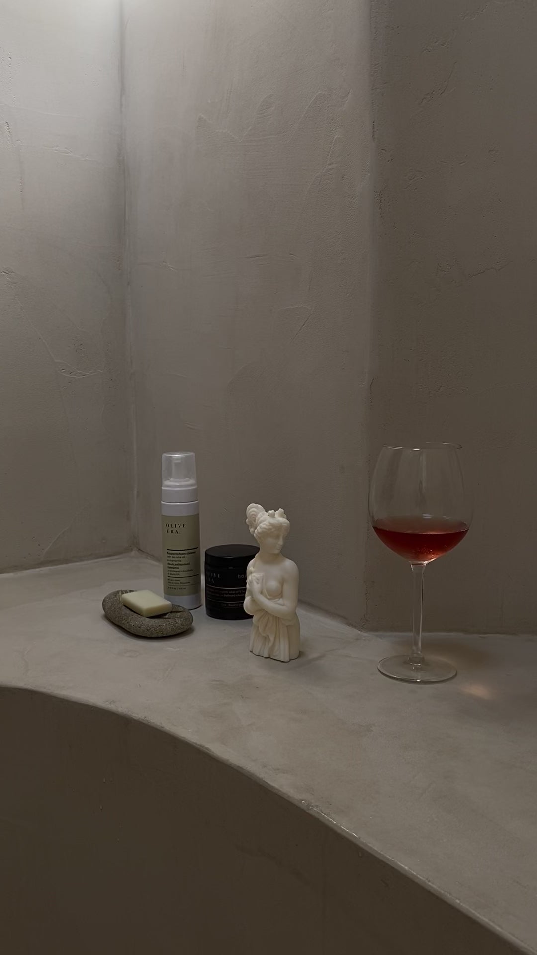 Video di una candela Lady Afrodite Ivory che viene accesa, accanto a un calice di vino e prodotti per il bagno
