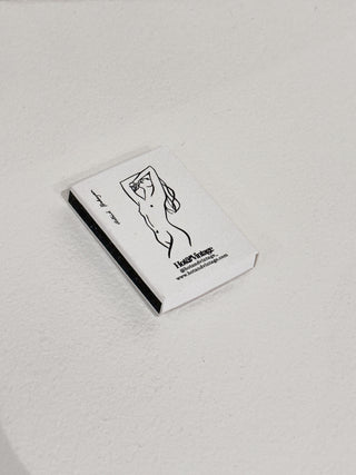 Scatola di fiammiferi illustrata da Astrid Babayan con una donna in posa.