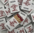 Diverse scatole di fiammiferi “Come On Baby, Light My Fire” sovrapposte, con la scritta rossa visibile.
