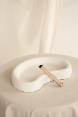 Vassoio Mezzaluna in Jesmonite decorato con una conchiglia e un accesorio in legno

